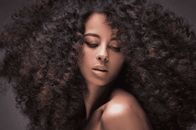 A woman with curly hair posing for a picture