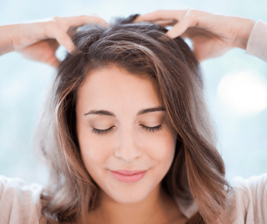 A woman is massaging her head.