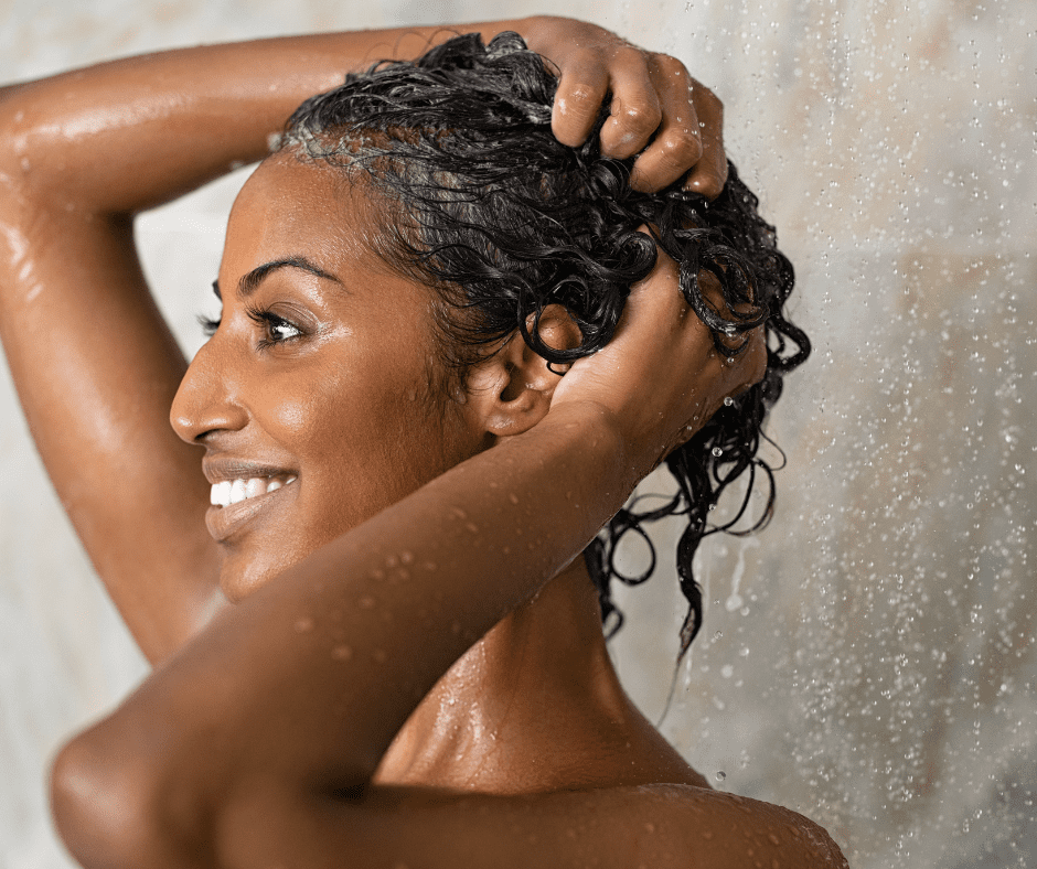 Woman showering with water on her hair.